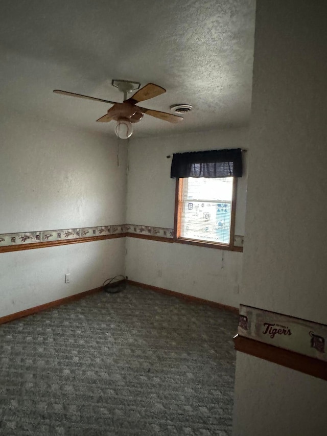 carpeted empty room with a textured ceiling and ceiling fan