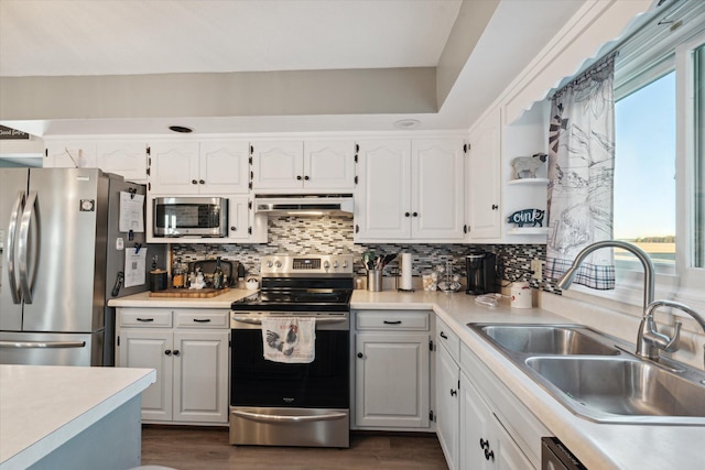 kitchen featuring a healthy amount of sunlight, appliances with stainless steel finishes, white cabinets, and extractor fan