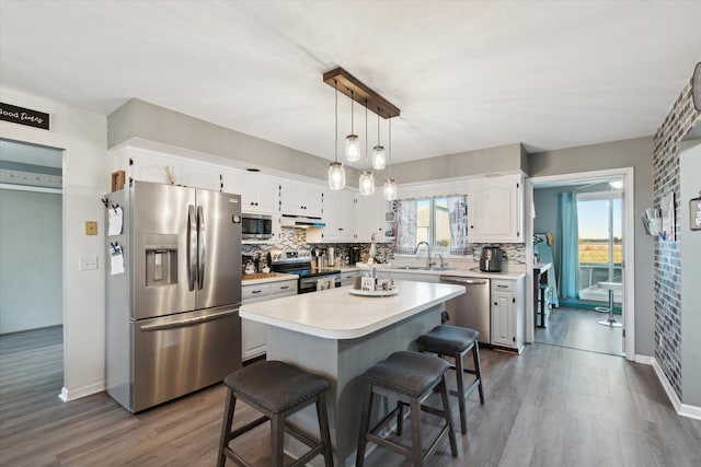 kitchen with a center island, white cabinetry, a healthy amount of sunlight, and stainless steel appliances