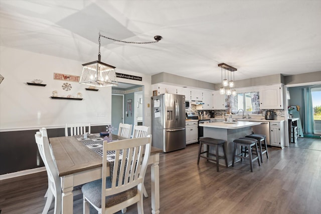 dining space featuring a chandelier, sink, and dark hardwood / wood-style flooring