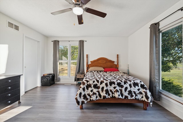 bedroom with a textured ceiling, hardwood / wood-style flooring, and ceiling fan