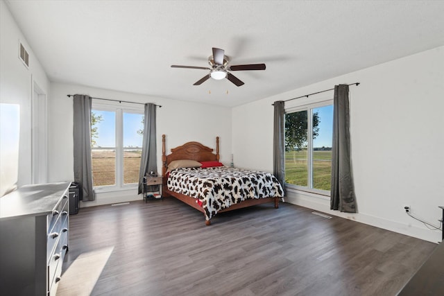 bedroom featuring a textured ceiling, dark wood-type flooring, and ceiling fan