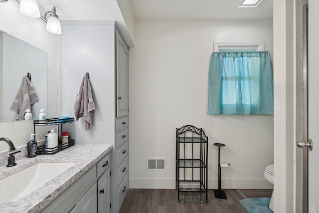 bathroom with vanity, toilet, and hardwood / wood-style floors