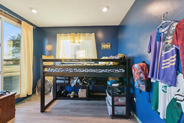 bedroom with a textured ceiling and wood-type flooring