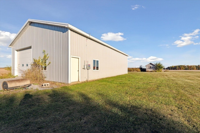 view of side of property featuring an outdoor structure, a yard, and a garage