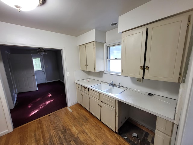 kitchen featuring sink, cream cabinets, ceiling fan, and light hardwood / wood-style flooring