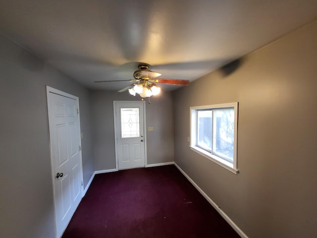 carpeted entryway with ceiling fan