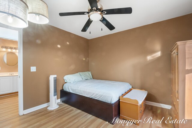 bedroom with light hardwood / wood-style floors, ensuite bathroom, and ceiling fan