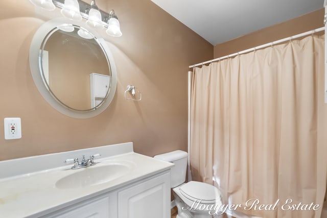 bathroom featuring vanity, toilet, and curtained shower