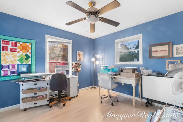 home office with light hardwood / wood-style floors and ceiling fan