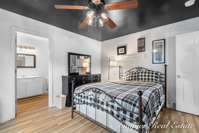 bedroom with connected bathroom, ceiling fan, sink, and light wood-type flooring