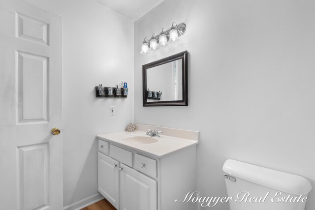 bathroom featuring vanity, wood-type flooring, and toilet