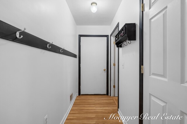 corridor with light hardwood / wood-style floors