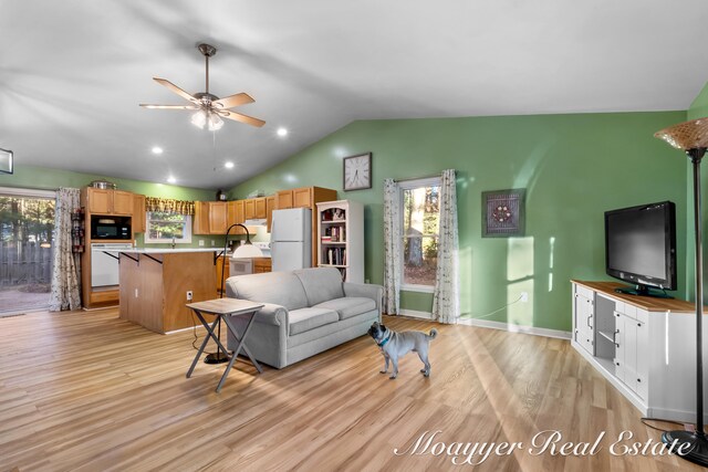 living room featuring sink, vaulted ceiling, light hardwood / wood-style flooring, and ceiling fan