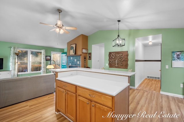 kitchen with a center island, vaulted ceiling, pendant lighting, and light hardwood / wood-style floors