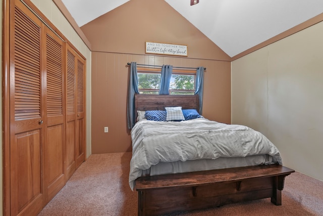 carpeted bedroom with lofted ceiling, a closet, and wooden walls