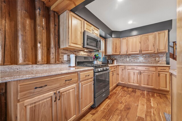 kitchen with light brown cabinets, light hardwood / wood-style flooring, decorative backsplash, and stainless steel appliances