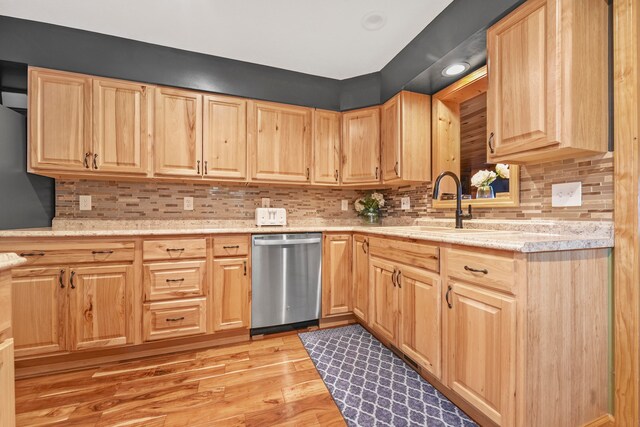 kitchen with light brown cabinetry, decorative backsplash, dishwasher, and light wood-type flooring