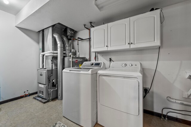 laundry room with washing machine and clothes dryer and cabinets