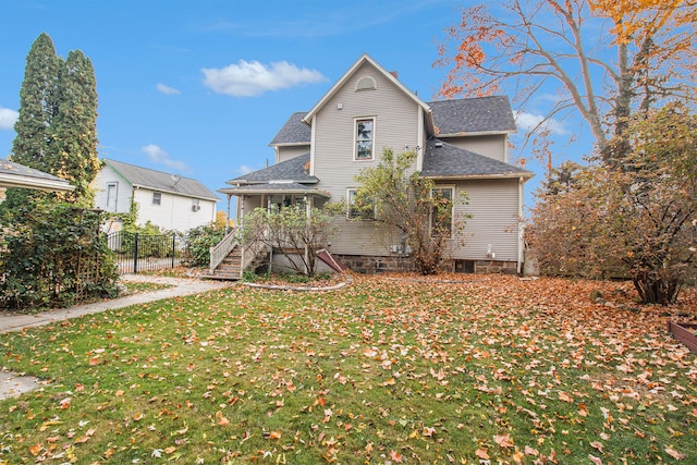 rear view of house featuring a lawn