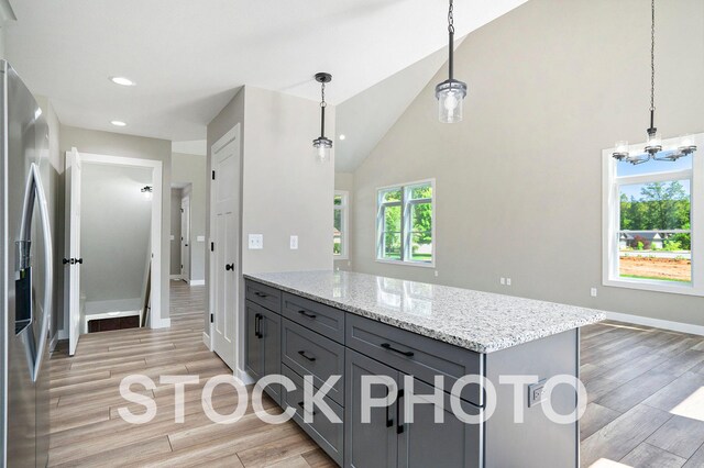 kitchen featuring stainless steel fridge, pendant lighting, gray cabinetry, and light wood-type flooring