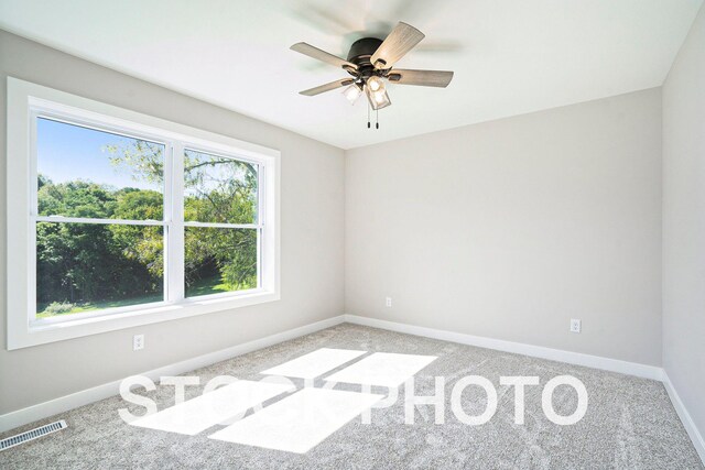 carpeted spare room featuring ceiling fan