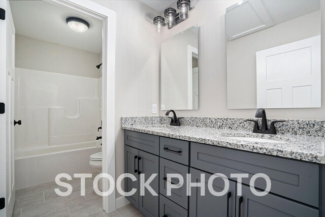 full bathroom featuring vanity, washtub / shower combination, toilet, and tile patterned flooring