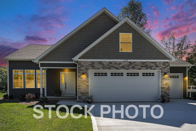 craftsman-style home featuring a garage and a lawn