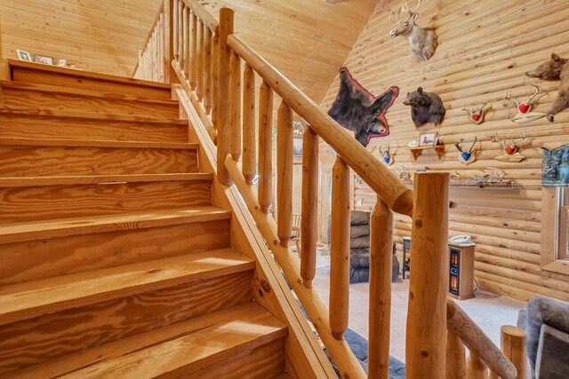 stairs with wood ceiling and log walls