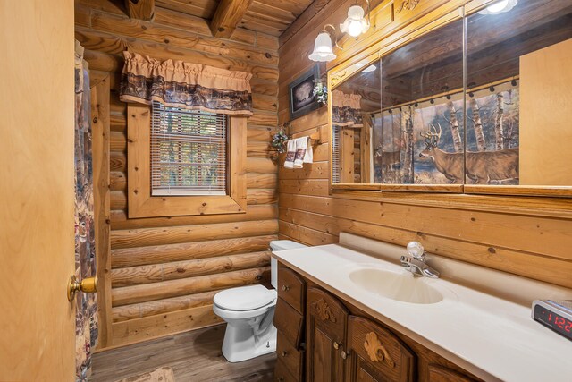 bathroom featuring toilet, beamed ceiling, hardwood / wood-style floors, log walls, and vanity