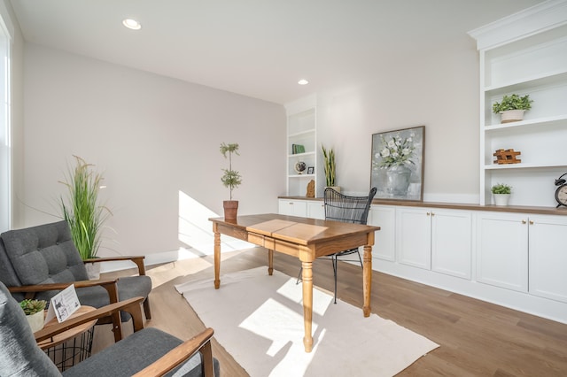 office area with light hardwood / wood-style flooring and built in features