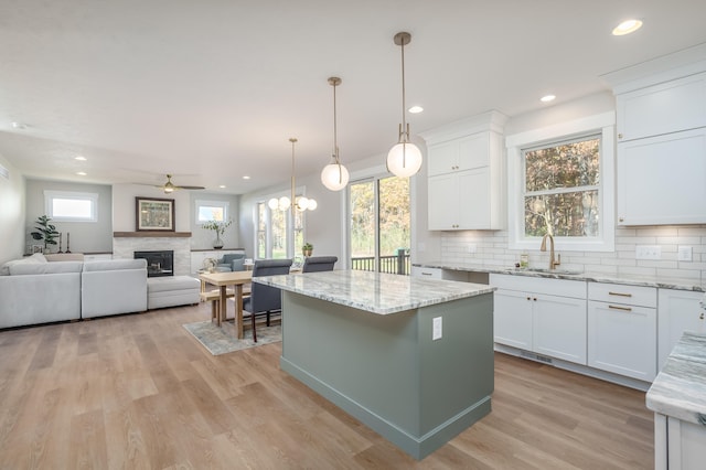 kitchen featuring white cabinetry, a center island, sink, and plenty of natural light