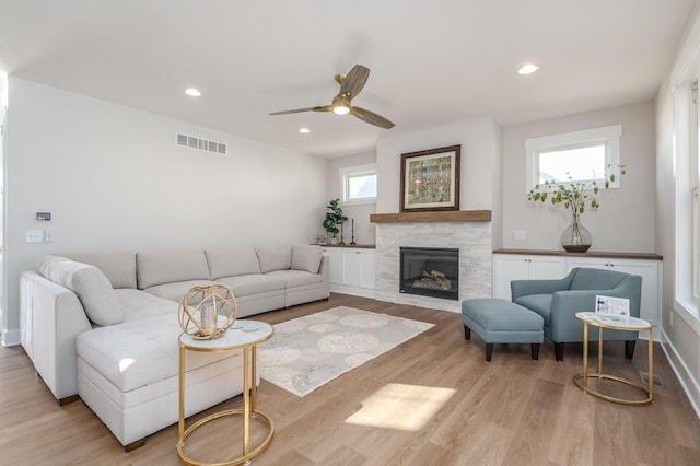 living room with light wood-type flooring, a healthy amount of sunlight, and ceiling fan