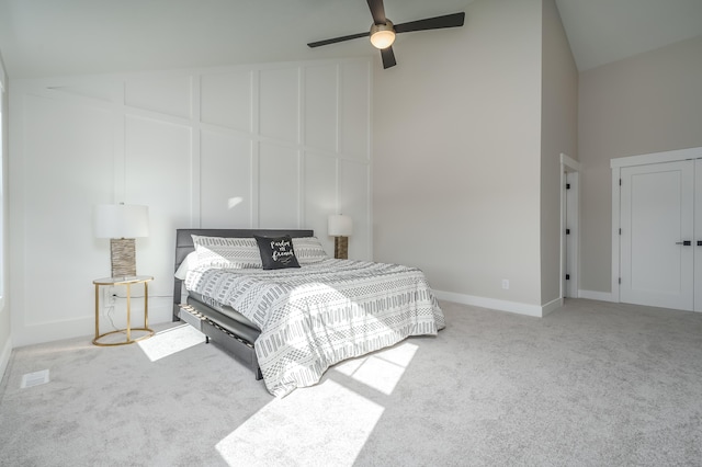 bedroom with ceiling fan, light carpet, and high vaulted ceiling