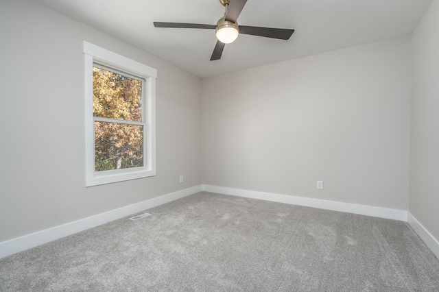 carpeted spare room with ceiling fan