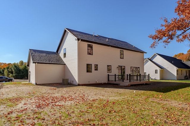 rear view of property with a yard, a deck, and central AC unit