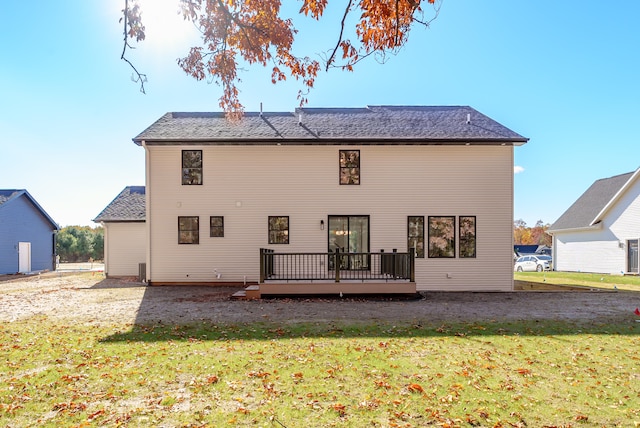 rear view of property with a wooden deck and a yard