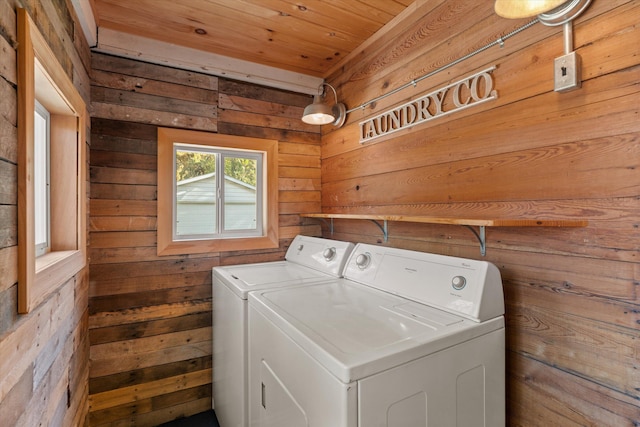 laundry room with wooden walls, wood ceiling, and separate washer and dryer