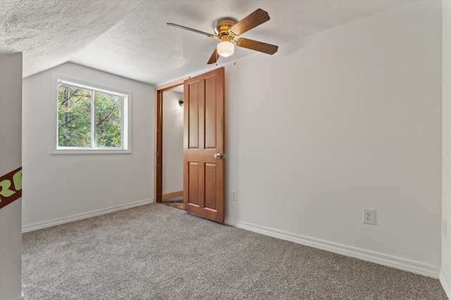 empty room with a textured ceiling, ceiling fan, carpet flooring, and vaulted ceiling