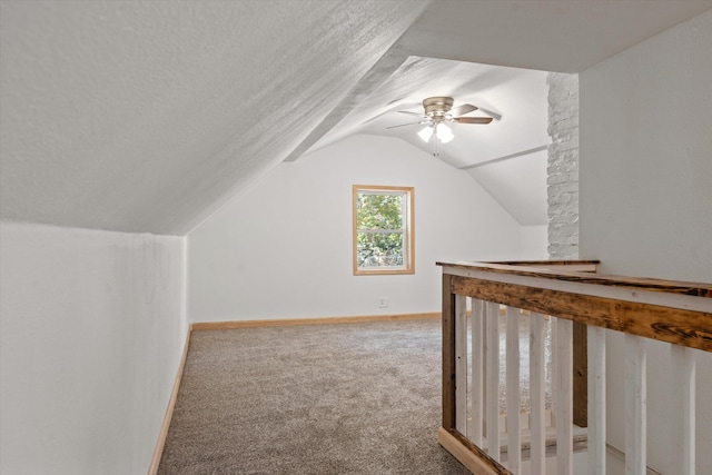 additional living space featuring carpet, vaulted ceiling, a textured ceiling, and ceiling fan