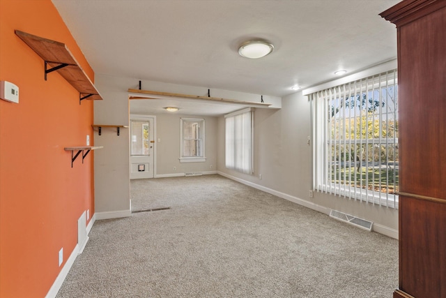 unfurnished room featuring a healthy amount of sunlight and light colored carpet