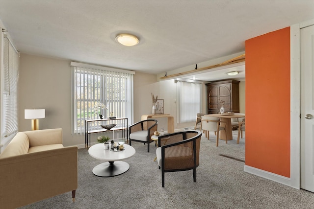 carpeted living room featuring a textured ceiling