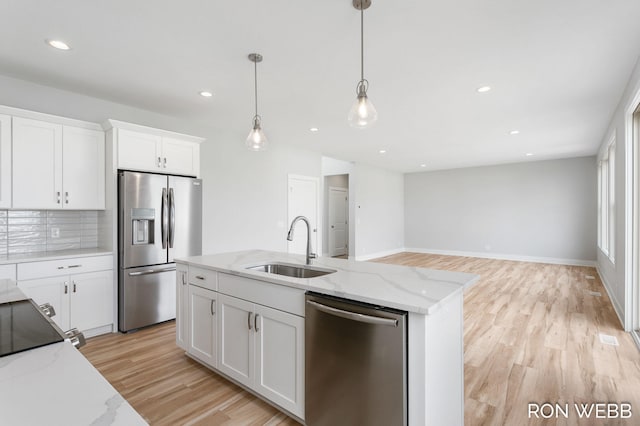 kitchen featuring light stone counters, white cabinetry, light hardwood / wood-style flooring, sink, and stainless steel appliances