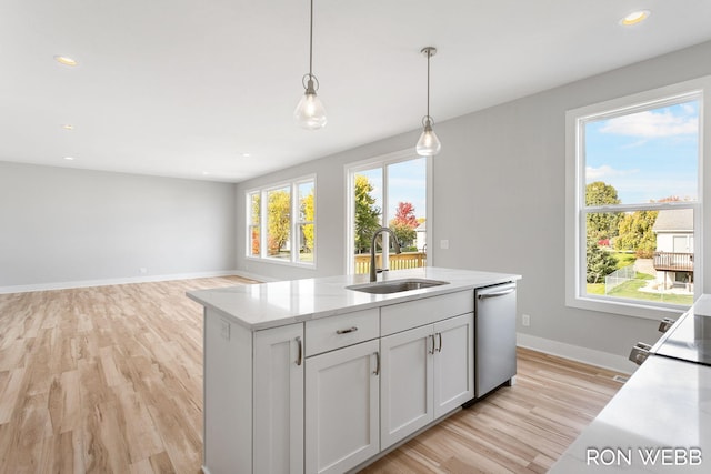 kitchen with light hardwood / wood-style flooring, hanging light fixtures, sink, and dishwasher