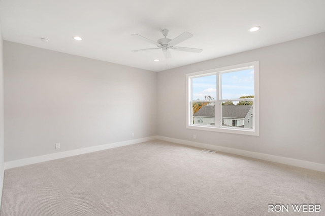 carpeted spare room featuring ceiling fan