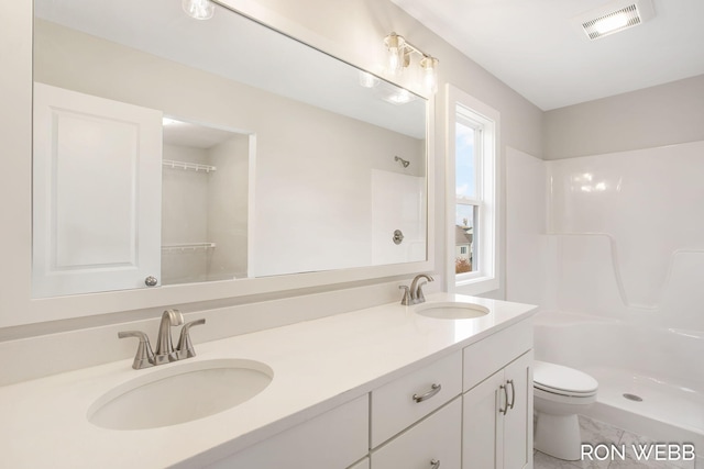 bathroom featuring toilet, walk in shower, and vanity