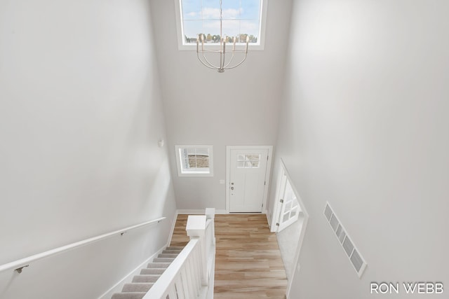 staircase with an inviting chandelier and hardwood / wood-style flooring