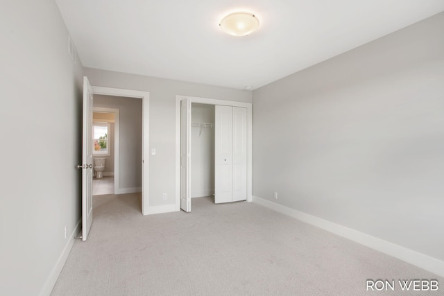 unfurnished bedroom with a closet and light colored carpet