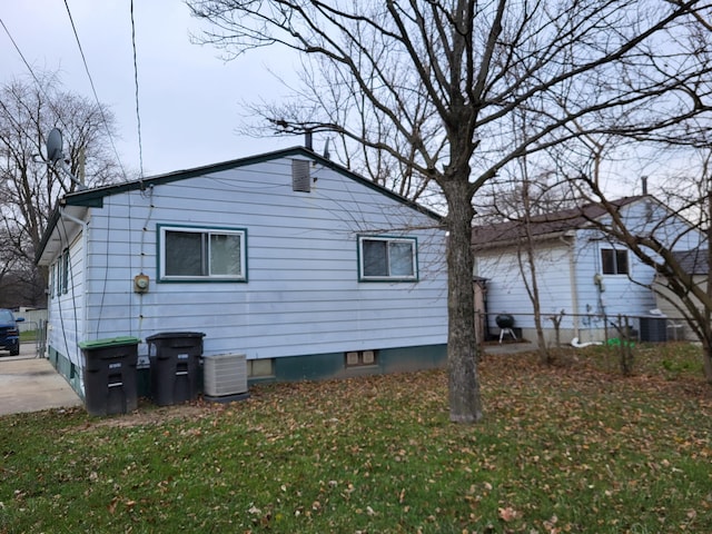 view of side of property with a yard and central AC unit