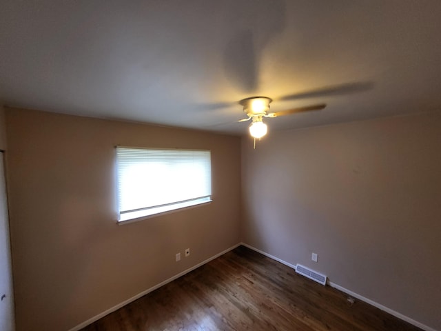 empty room with ceiling fan and dark wood-type flooring